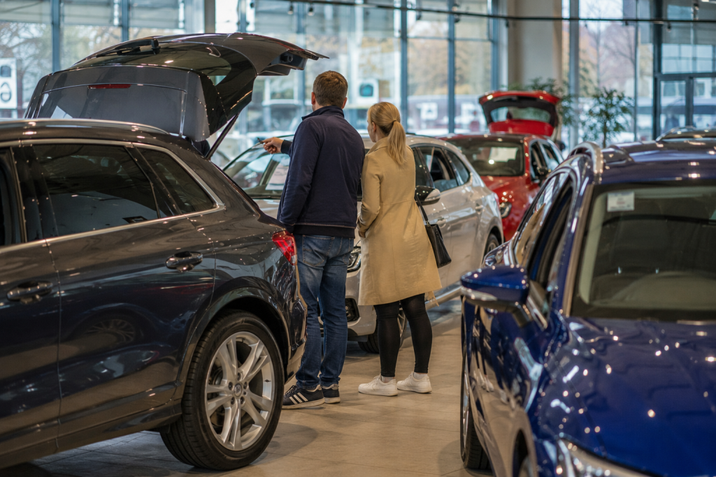 People exploring cars at a showroom in UK